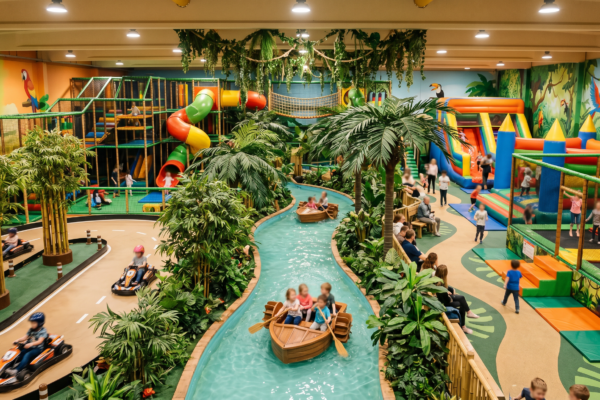 Tropisch gestalteter Indoor-Spielplatz mit Bambus, Palmen und Wasserlauf im Bambooland Berlin-Spandau