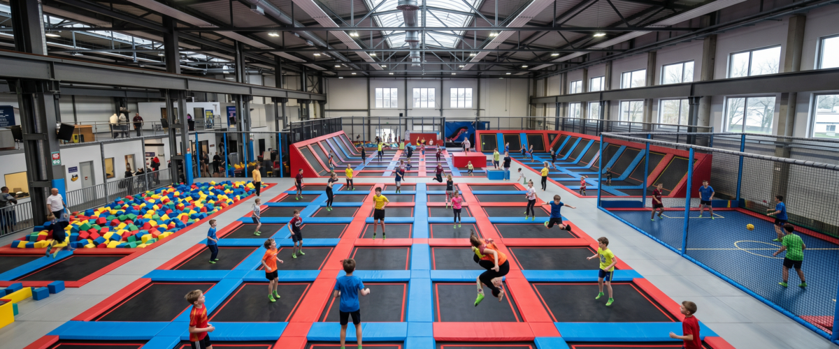 Blick in den grossen Trampolinpark UMP House Berlin in Reinickendorf mit vernetzten Sprungtrampolinen, Freestyle-Bereich, Dodgeball-Court und Schaumstoffgrube