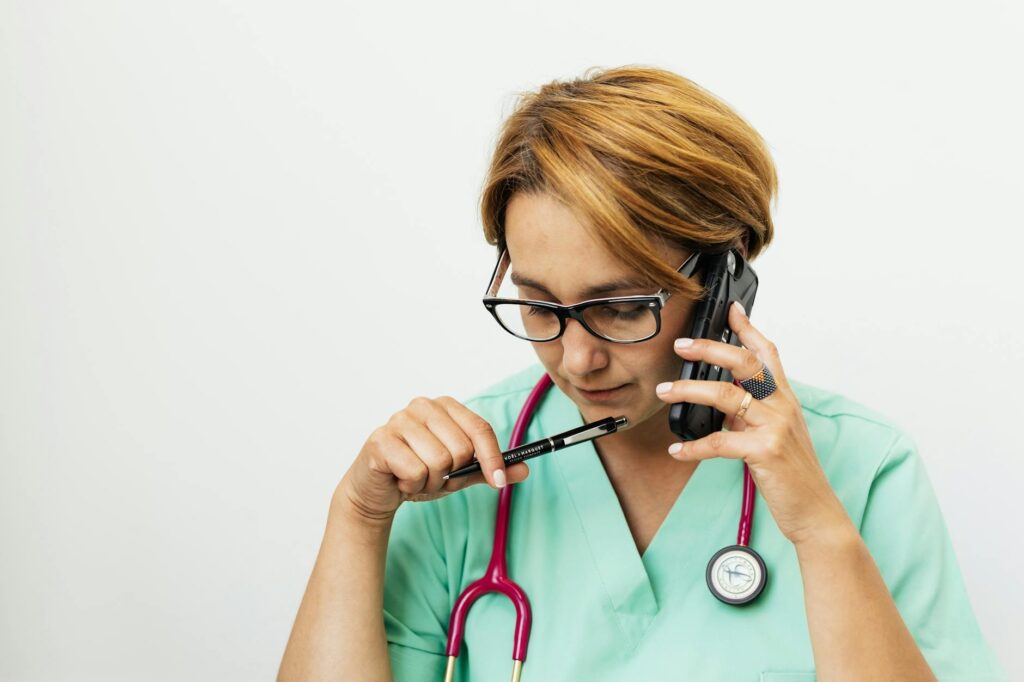 Ein freundlicher Arzt f&uuml;hrt ein Beratungsgespr&auml;ch am Telefon im Rahmen des 116117 Berlin Services und gibt einem Patienten medizinische Ratschl&auml;ge.