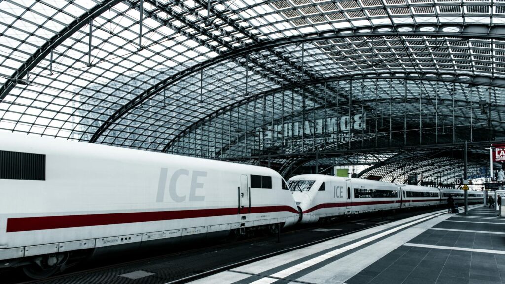 Anbindung am Bahnhof Spandau: Ein ICE am Bahnsteig Ein weißer ICE-Zug steht abfahrbereit am Bahnsteig des Bahnhofs Spandau, während Fahrgäste ein- und aussteigen.