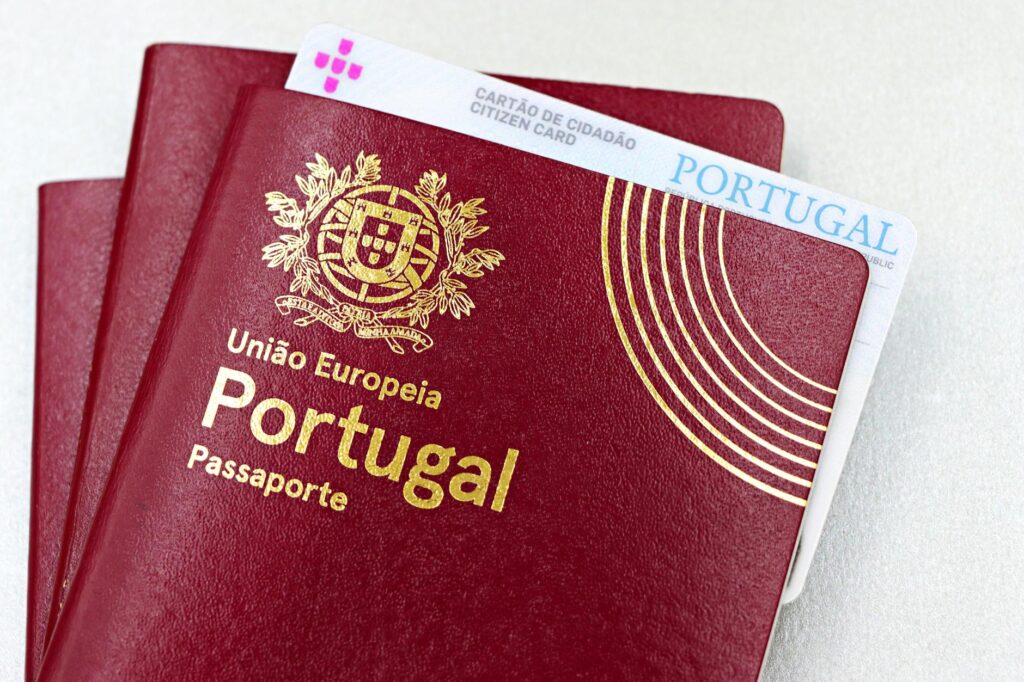 Ein deutscher Personalausweis und Reisepass liegen neben einem biometrischen Passfoto auf einem Tisch.