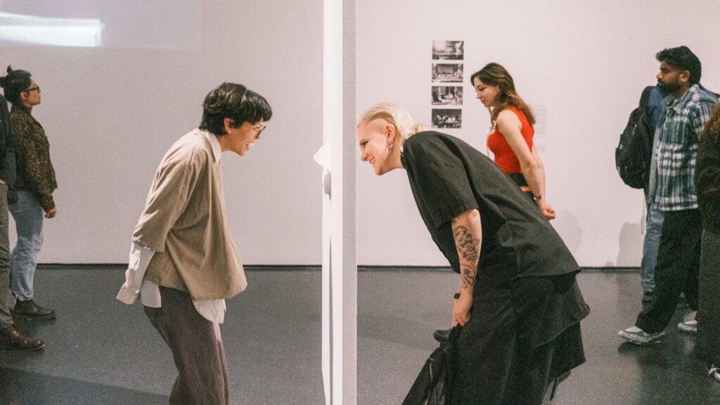 Eine Gruppe von Menschen betrachtet aufmerksam eine Installation in einem der Top Museen Berlins.
