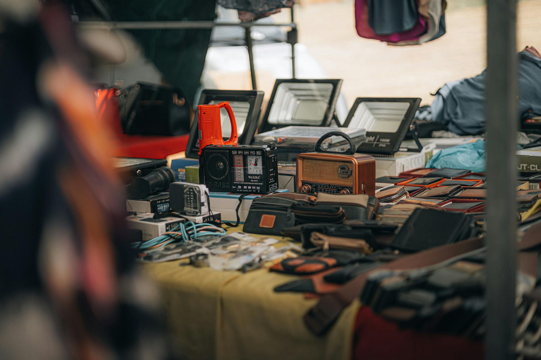 Ein belebter Stand auf dem Flohmarkt Boxhagener Platz, an dem Besucher in Kisten mit Second-Hand-Waren und Vintage-Artikeln stöbern.