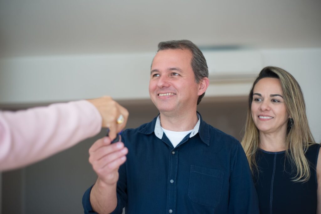 Erfolgreiche Wohnungssuche mit dem WBS Marzahn Eine Person übergibt einer anderen einen Schlüsselbund für eine neue Wohnung, die mit einem WBS Marzahn gefunden wurde.