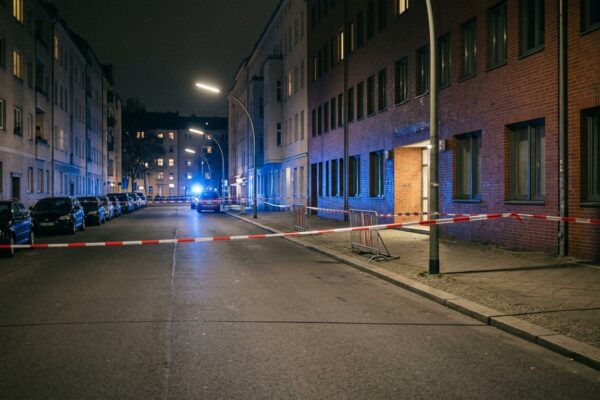 Schüsse vor Polizeiwache Moabit: Blaulicht und Absperrband bei Nacht an einer menschenleeren Berliner Straße, saubere leere Fahrbahn ohne Gegenstände und ohne Spuren