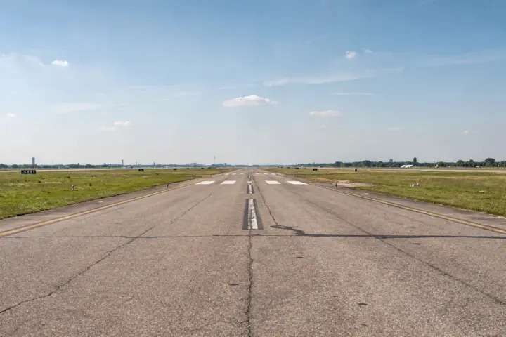 Weite Fläche des Tempelhofer Felds in Berlin mit Radfahrern und Picknick auf der ehemaligen Startbahn.